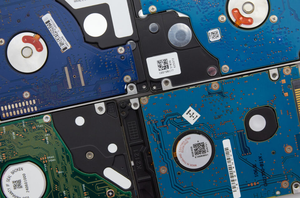 A stack of hard drives with their circuit boards showing