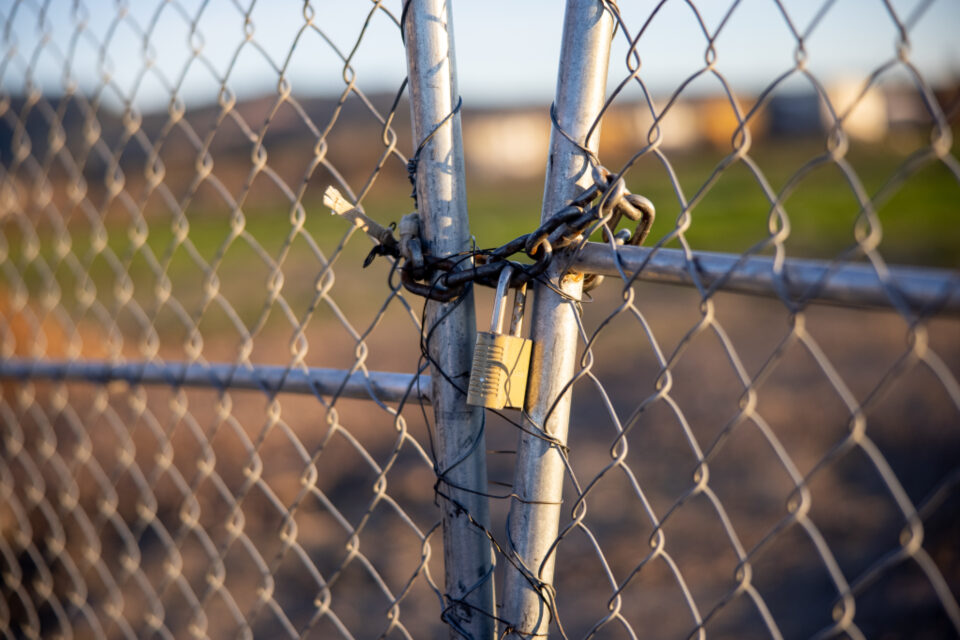 A padlock on a chain-link gate